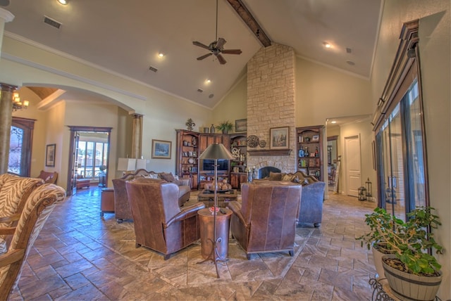 living room featuring high vaulted ceiling, ornamental molding, a stone fireplace, beamed ceiling, and ornate columns