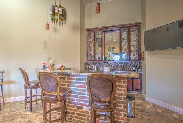 bar with ornamental molding, stone countertops, and decorative backsplash