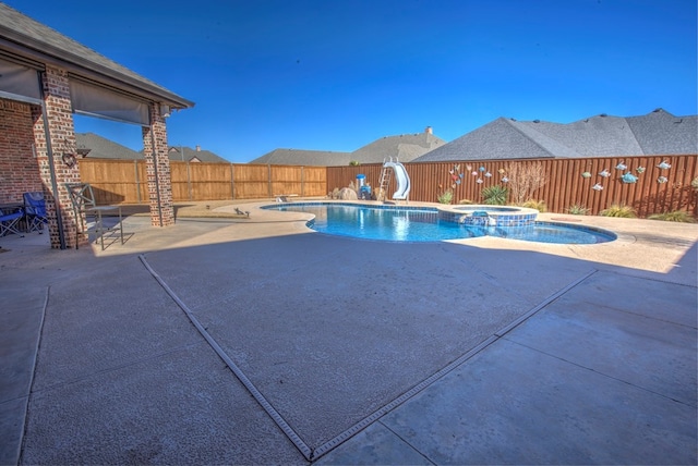 view of swimming pool with an in ground hot tub, a patio, and a water slide