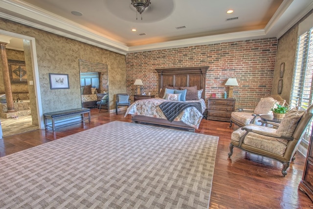 bedroom with dark hardwood / wood-style flooring, crown molding, decorative columns, and brick wall