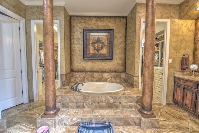 bathroom with crown molding, tiled bath, and ornate columns