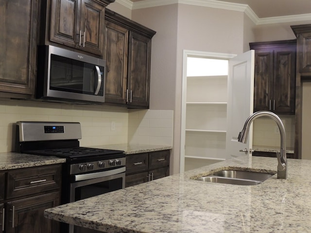 kitchen with light stone counters, sink, and stainless steel appliances