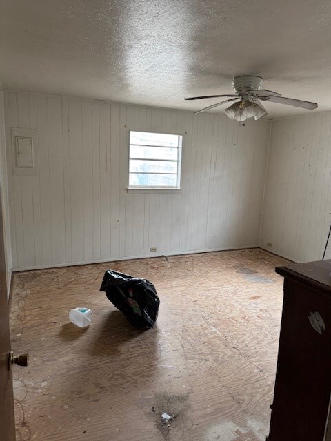 empty room featuring ceiling fan and a textured ceiling