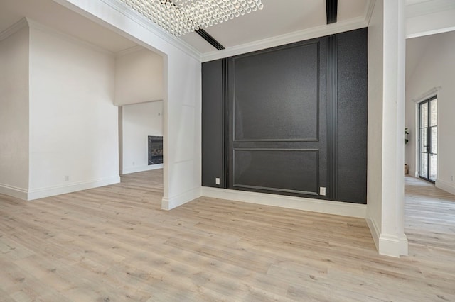 interior space with an inviting chandelier, ornamental molding, and light hardwood / wood-style floors