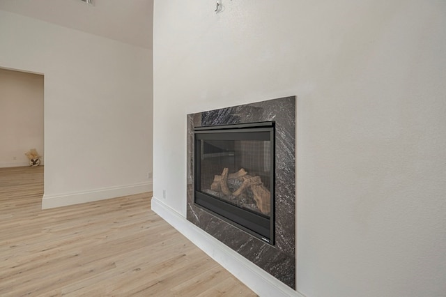 room details featuring hardwood / wood-style flooring and a premium fireplace