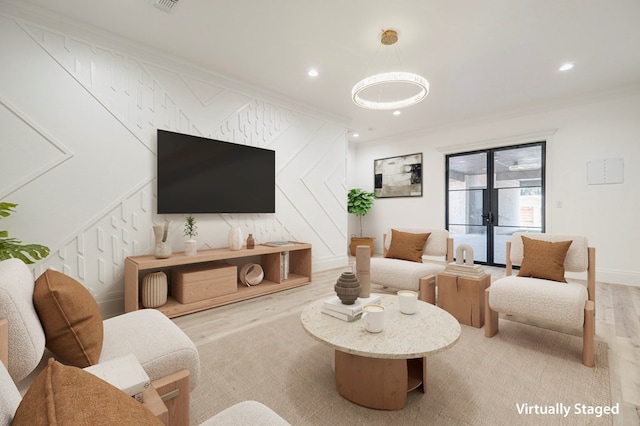 living room featuring ornamental molding, light hardwood / wood-style floors, and french doors