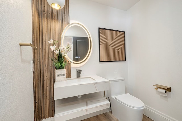 bathroom with hardwood / wood-style flooring, vanity, and toilet