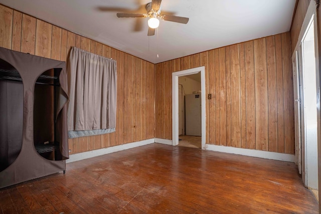 206 Austin, Big Spring, TX 79720 - empty room with ceiling fan, wood finished floors, and wood walls