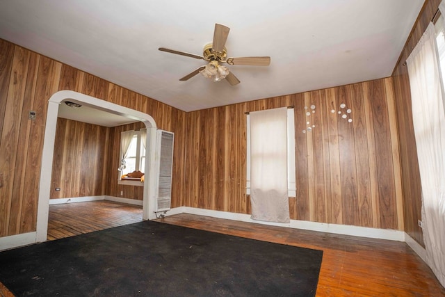 206 Austin, Big Spring, TX 79720 - spare room featuring hardwood / wood-style flooring, a ceiling fan, a heating unit, and wood walls