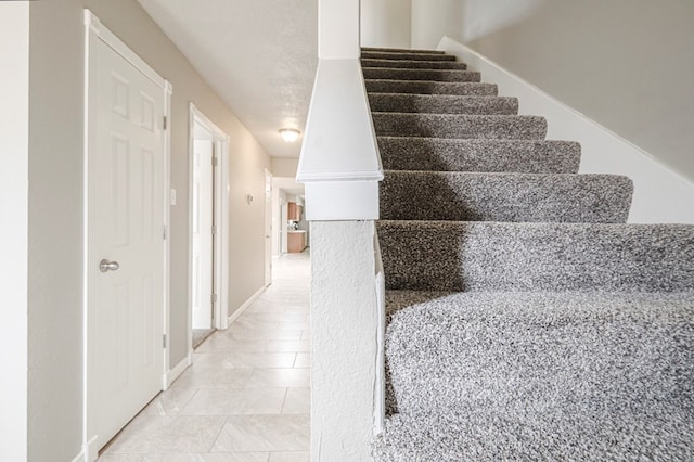 stairs with tile patterned flooring and baseboards