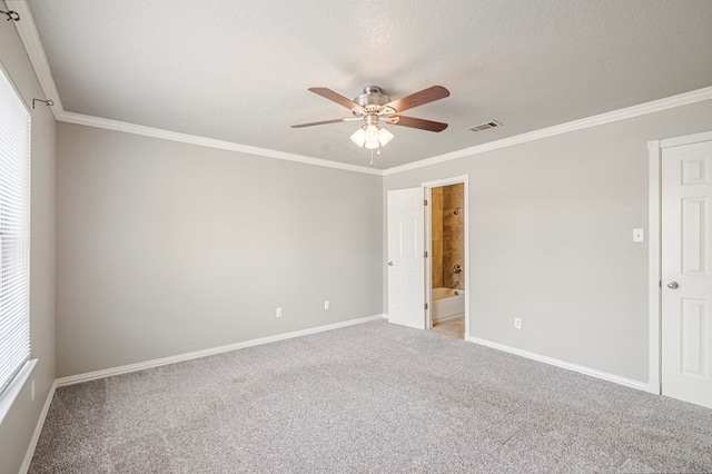 carpeted empty room with baseboards, a ceiling fan, visible vents, and crown molding