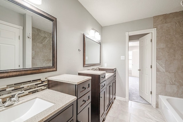 bathroom featuring baseboards, two vanities, a sink, and decorative backsplash