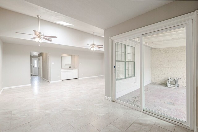 spare room featuring ceiling fan, baseboards, and vaulted ceiling