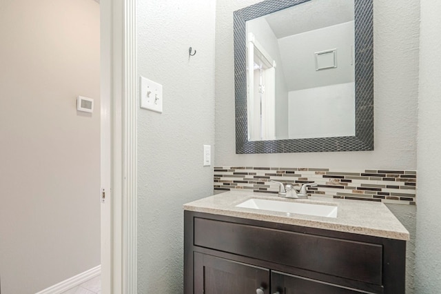 bathroom with backsplash, vanity, and baseboards