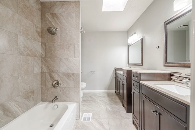 bathroom with a skylight, tiled shower / bath, visible vents, toilet, and vanity