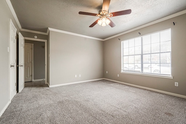 carpeted empty room with a ceiling fan, a textured ceiling, baseboards, and crown molding