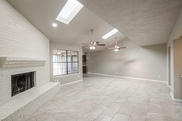 unfurnished living room featuring high vaulted ceiling, a skylight, a fireplace, and baseboards