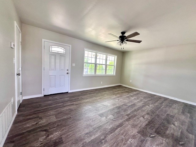 entryway featuring visible vents, a ceiling fan, dark wood-style flooring, and baseboards