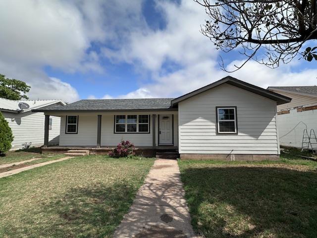 single story home with covered porch and a front yard
