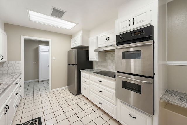 kitchen with white cabinets, appliances with stainless steel finishes, backsplash, and light stone counters