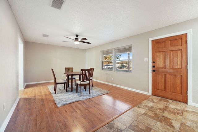 dining space with wood-type flooring, a textured ceiling, and ceiling fan