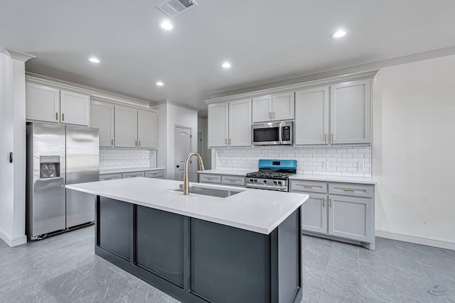 kitchen with stainless steel appliances, tasteful backsplash, sink, and a kitchen island with sink