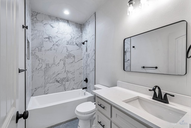 full bathroom featuring tiled shower / bath, vanity, and toilet