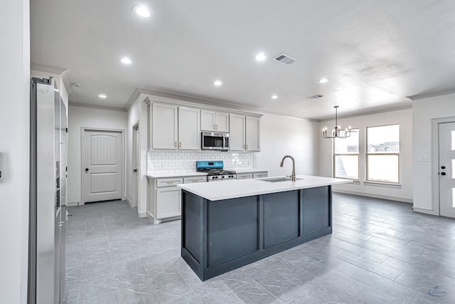 kitchen with tasteful backsplash, sink, an island with sink, and appliances with stainless steel finishes