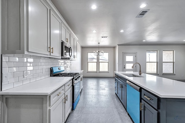 kitchen featuring gray cabinets, an island with sink, appliances with stainless steel finishes, and sink