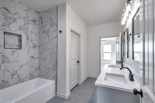 bathroom featuring tiled shower / bath and vanity