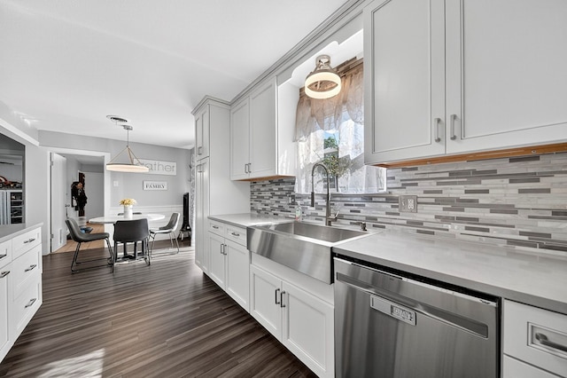 3202 Maxwell Dr, Midland, TX 79705 - kitchen featuring stainless steel dishwasher, light countertops, backsplash, and hanging light fixtures