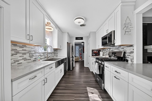 3202 Maxwell Dr, Midland, TX 79705 - kitchen featuring stainless steel appliances, tasteful backsplash, white cabinetry, dark wood-type flooring, and light countertops