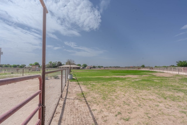 view of yard with fence and a rural view