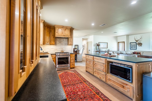kitchen featuring visible vents, black microwave, dark countertops, recessed lighting, and stainless steel range