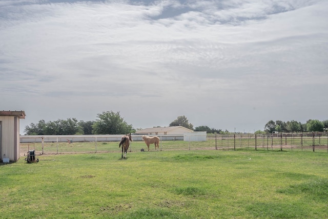 view of yard with fence and a rural view