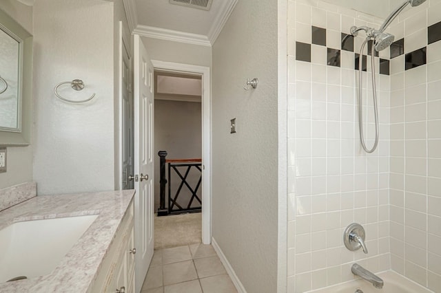 bathroom featuring vanity, tiled shower / bath, tile patterned flooring, and ornamental molding