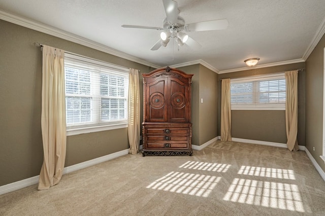 unfurnished bedroom with ceiling fan, ornamental molding, and light carpet