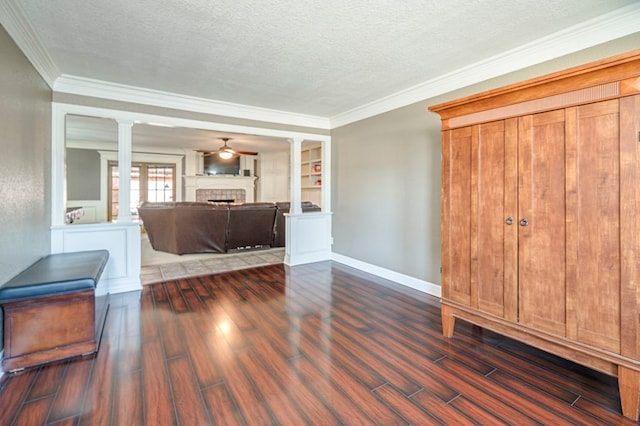 interior space featuring built in shelves, decorative columns, a textured ceiling, and dark hardwood / wood-style flooring