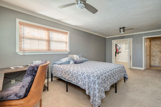 bedroom featuring a textured ceiling, light colored carpet, ceiling fan, and ornamental molding