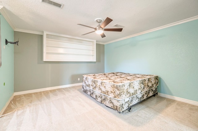 carpeted bedroom featuring ceiling fan, a textured ceiling, and crown molding