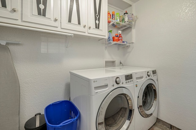 washroom featuring cabinets and independent washer and dryer