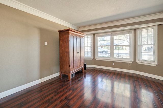 empty room with crown molding, a textured ceiling, and dark hardwood / wood-style floors