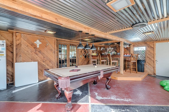 rec room featuring french doors, a wood stove, billiards, wooden walls, and bar