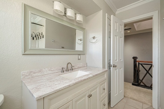 bathroom featuring tile patterned floors, crown molding, and vanity