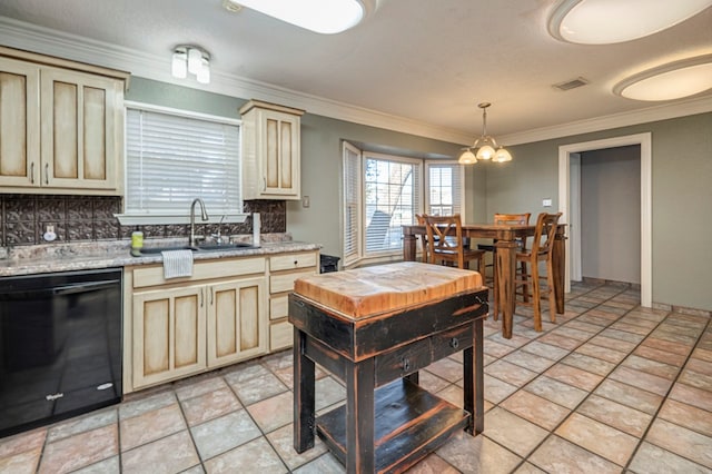 kitchen with backsplash, cream cabinets, dishwasher, and pendant lighting