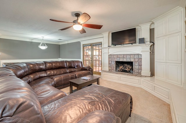 living room featuring french doors, a fireplace, ceiling fan, light colored carpet, and crown molding