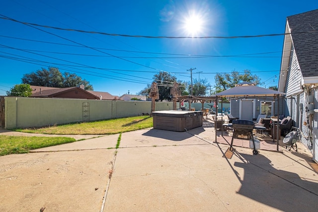 view of patio / terrace featuring an outdoor fire pit, a gazebo, and a hot tub