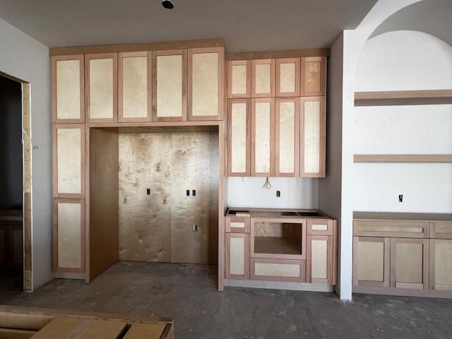 kitchen with glass insert cabinets and unfinished concrete floors