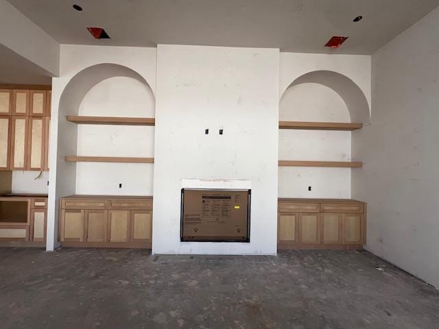 unfurnished living room with unfinished concrete floors