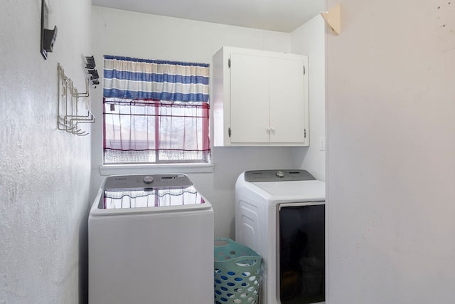 laundry room with washer and dryer and cabinets